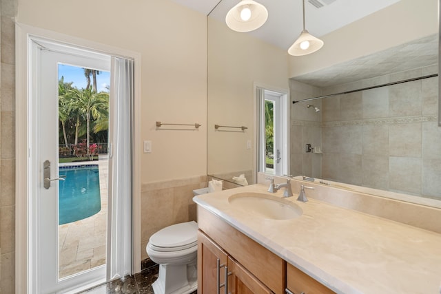 bathroom featuring tile walls, vanity, a wealth of natural light, and toilet