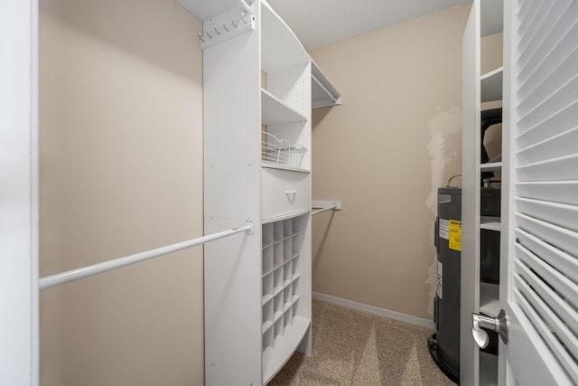 spacious closet with electric water heater and carpet