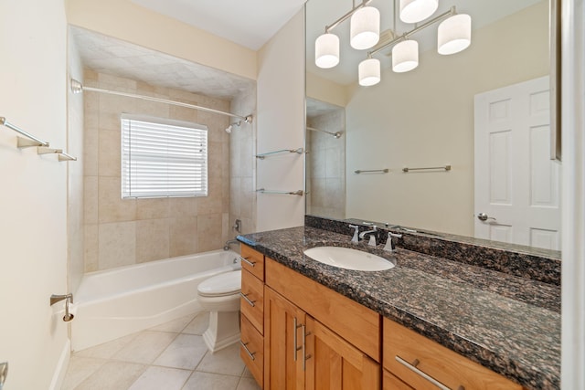 full bathroom with tile patterned flooring, tiled shower / bath, vanity, and toilet