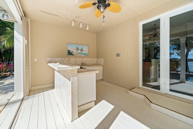 deck with an outdoor wet bar and ceiling fan