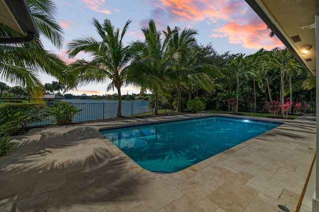 pool at dusk with a patio