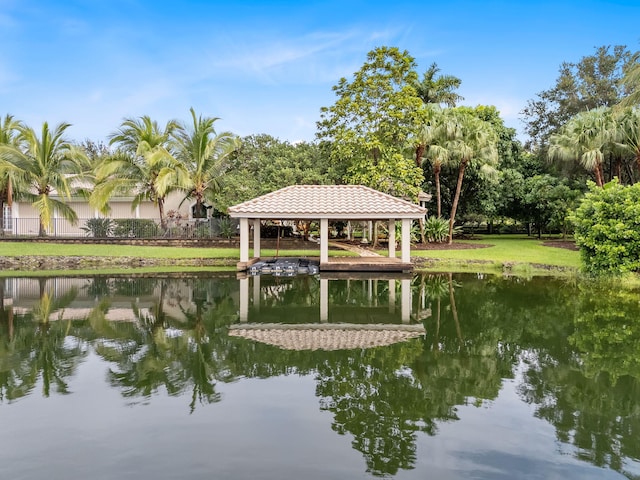 view of dock with a gazebo, a yard, and a water view