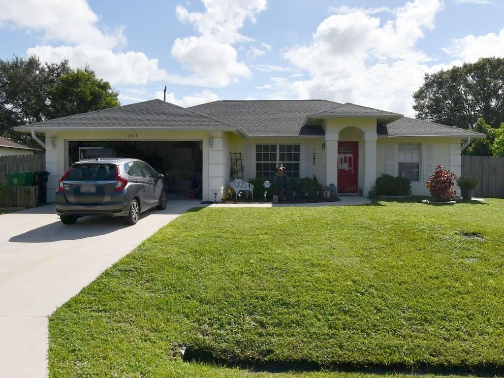 ranch-style house featuring a garage and a front lawn