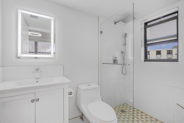 bathroom featuring walk in shower, a wealth of natural light, vanity, and toilet