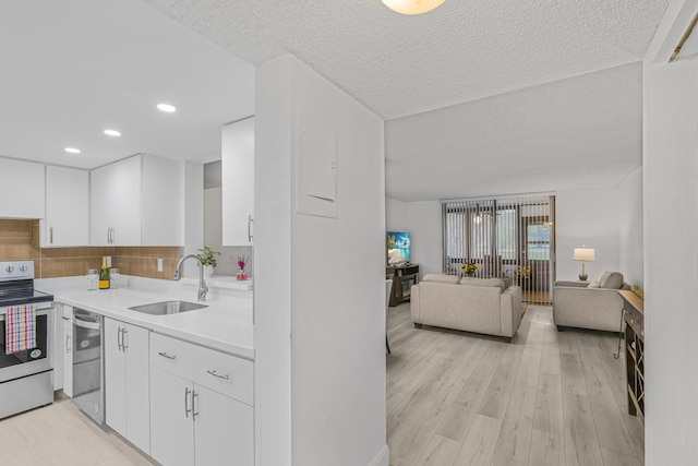 kitchen featuring appliances with stainless steel finishes, sink, decorative backsplash, and white cabinets