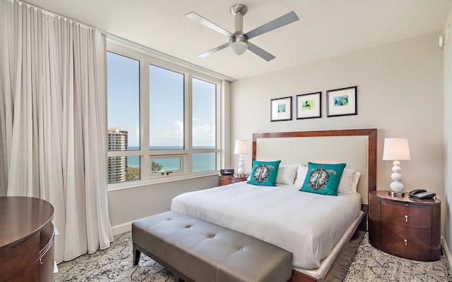 bedroom featuring a water view and ceiling fan