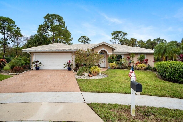 ranch-style house with a garage and a front lawn