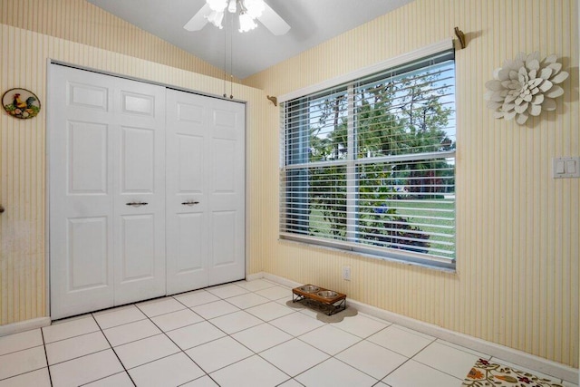 unfurnished bedroom featuring multiple windows, light tile patterned flooring, ceiling fan, and a closet