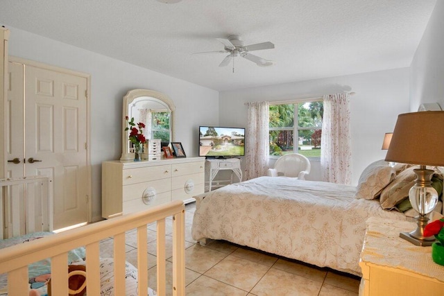 tiled bedroom with a textured ceiling and ceiling fan