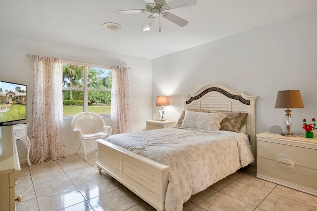 bedroom featuring light tile patterned flooring, a textured ceiling, and ceiling fan