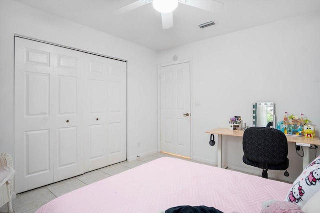 tiled bedroom featuring ceiling fan and a closet