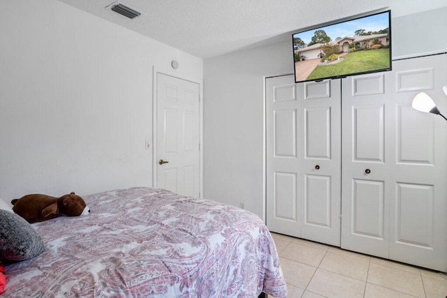 tiled bedroom featuring a closet and a textured ceiling