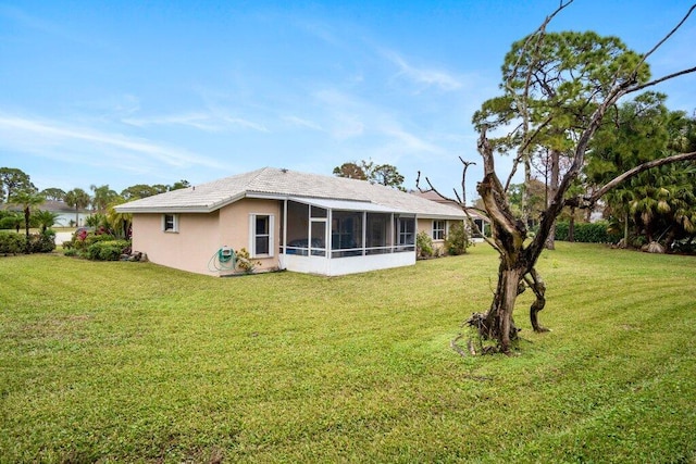 back of property with a sunroom and a lawn