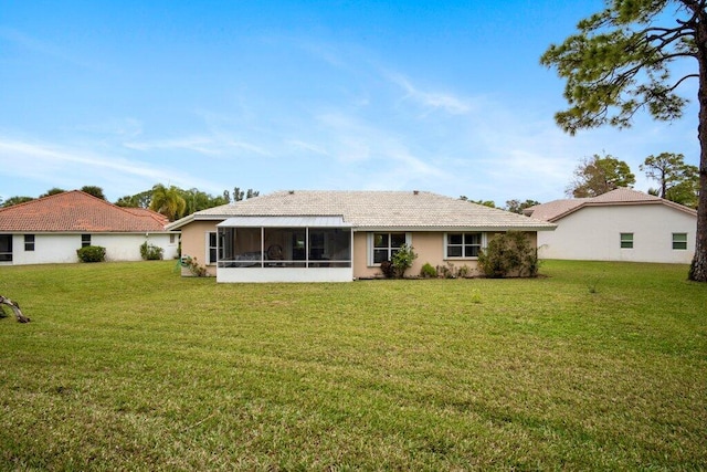 back of property with a yard and a sunroom