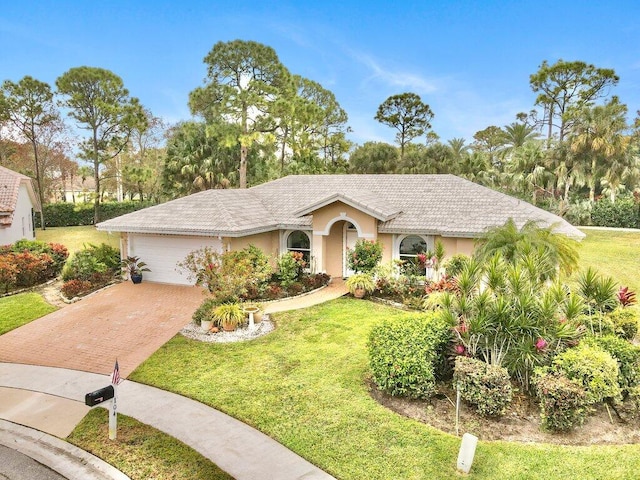 ranch-style home with a garage and a front lawn