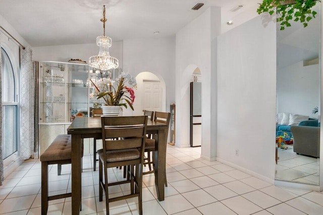 dining area with light tile patterned floors and a notable chandelier