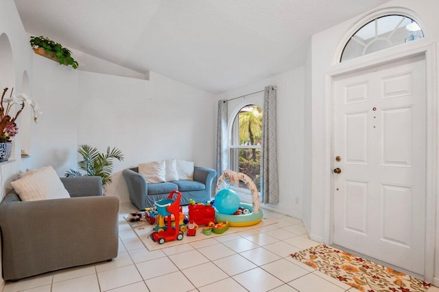 foyer entrance featuring light tile patterned flooring and lofted ceiling