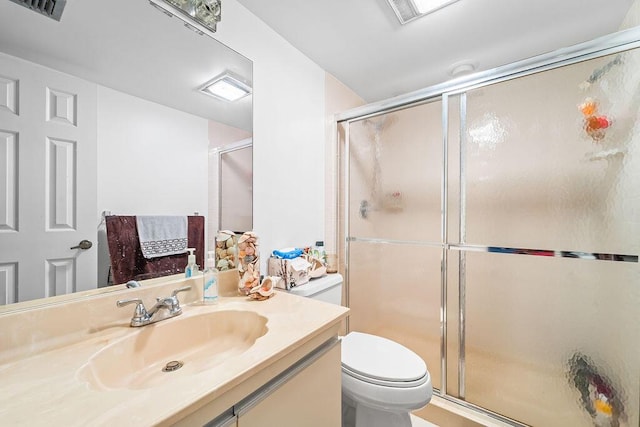 bathroom featuring vanity, toilet, and walk in shower