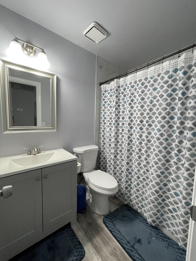 bathroom featuring vanity, toilet, a shower with curtain, and hardwood / wood-style flooring