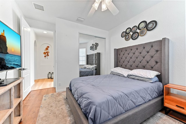 bedroom featuring ceiling fan, light hardwood / wood-style floors, and a closet