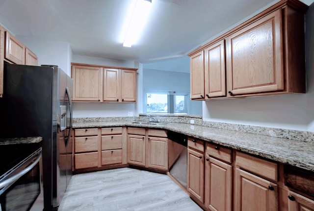 kitchen with sink, stainless steel appliances, light hardwood / wood-style floors, and light stone countertops