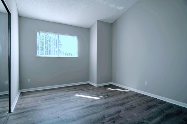 spare room featuring hardwood / wood-style floors and a textured ceiling