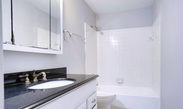 full bathroom featuring toilet, tiled shower / bath, and vanity