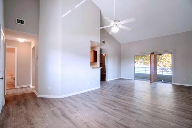 unfurnished living room with light wood-type flooring, high vaulted ceiling, and ceiling fan