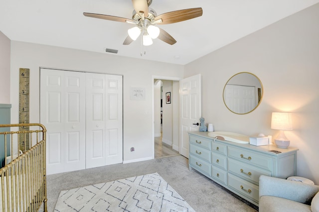 carpeted bedroom with ceiling fan and a closet