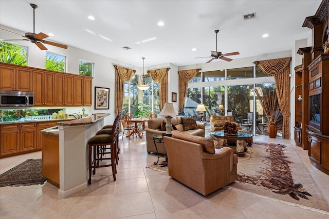 tiled living room featuring a high ceiling and ceiling fan