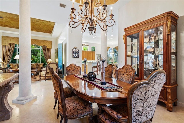 dining area with decorative columns, light tile patterned floors, and an inviting chandelier