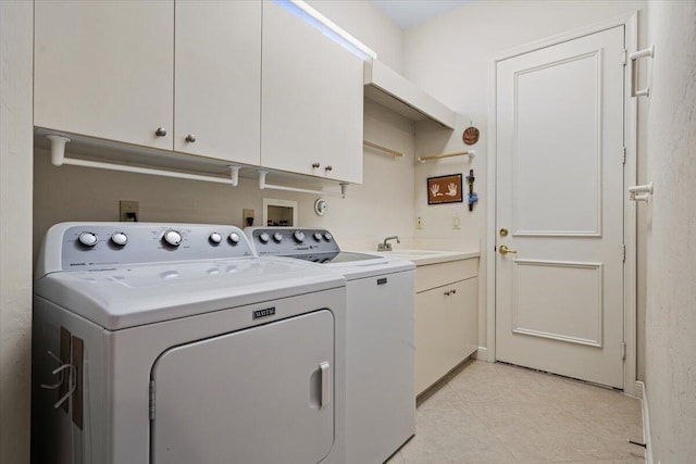 laundry area featuring cabinets, washer and clothes dryer, and sink