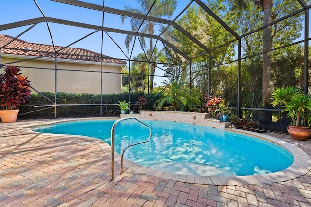 view of pool with glass enclosure and a patio area