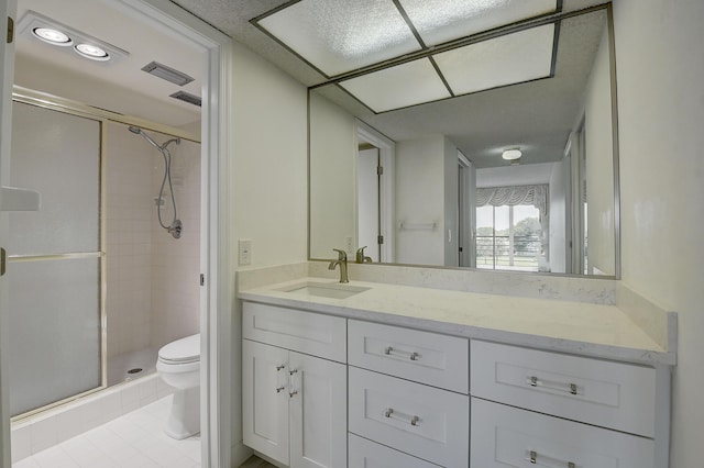 bathroom with a shower with shower door, toilet, vanity, and tile patterned flooring