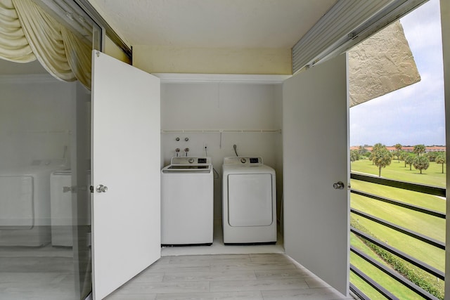 laundry room with light wood-type flooring and separate washer and dryer