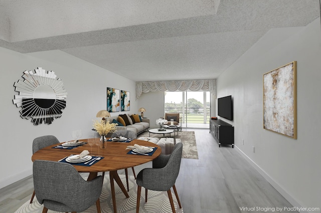 dining room featuring light hardwood / wood-style floors and a textured ceiling