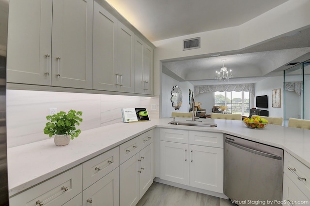 kitchen with tasteful backsplash, a chandelier, stainless steel dishwasher, sink, and pendant lighting