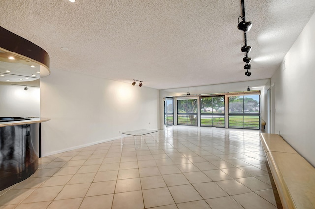 unfurnished living room featuring light tile patterned floors and rail lighting