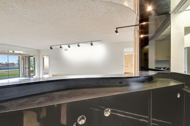 interior space featuring track lighting and a textured ceiling