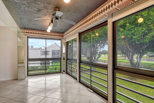 unfurnished sunroom featuring ceiling fan