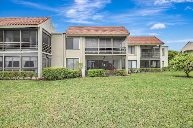 5519 Fairway Park Dr Unit 202, Boynton Beach, FL 33437 - rear view of property with a tiled roof, stucco siding, a yard, and a sunroom