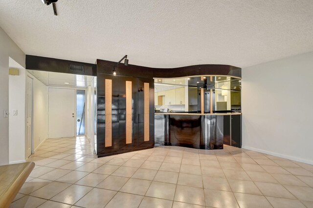 5519 Fairway Park Dr Unit 202, Boynton Beach, FL 33437 - bar featuring a textured ceiling, light tile patterned floors, and baseboards