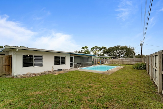 back of property with a fenced in pool, a yard, and a sunroom