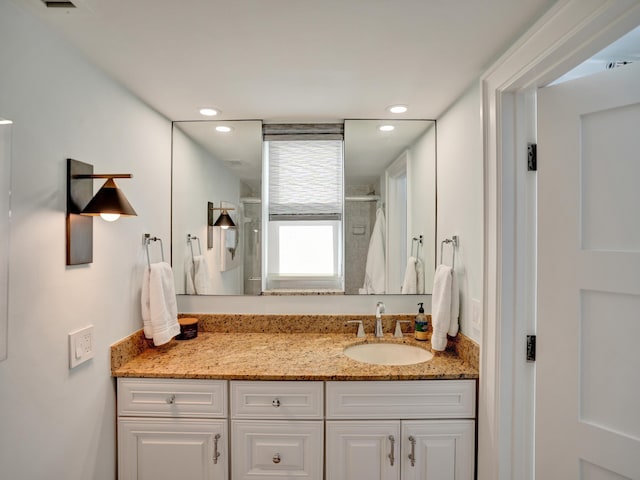 bathroom with vanity and a shower with door