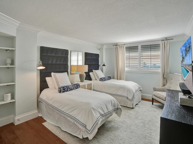 bedroom featuring crown molding, wood-type flooring, and a textured ceiling