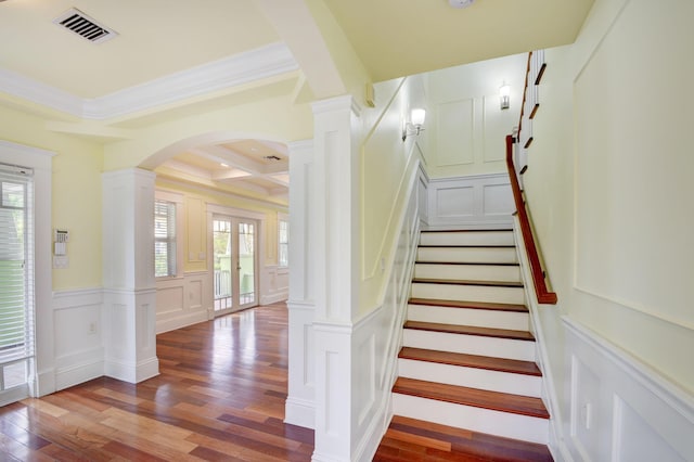 stairs featuring crown molding, beamed ceiling, hardwood / wood-style flooring, decorative columns, and coffered ceiling