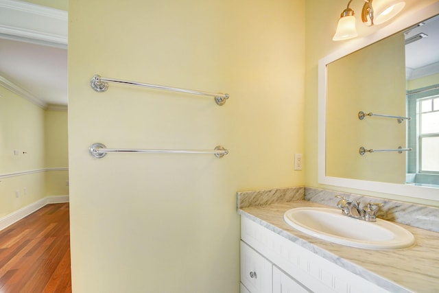 bathroom with vanity, crown molding, and wood-type flooring