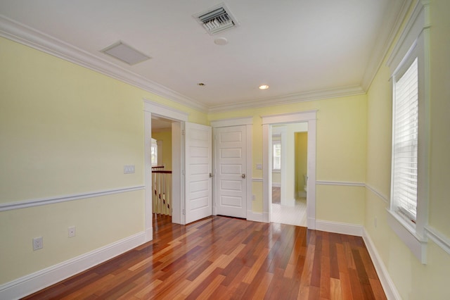 spare room with ornamental molding and wood-type flooring