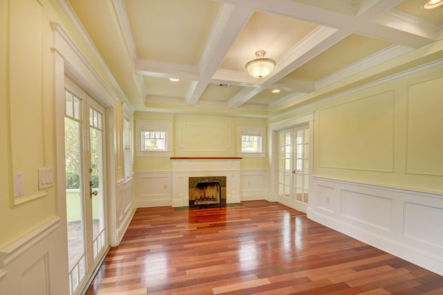 unfurnished living room with hardwood / wood-style floors, crown molding, french doors, beam ceiling, and a premium fireplace