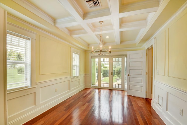 unfurnished sunroom with a notable chandelier, coffered ceiling, french doors, and beam ceiling